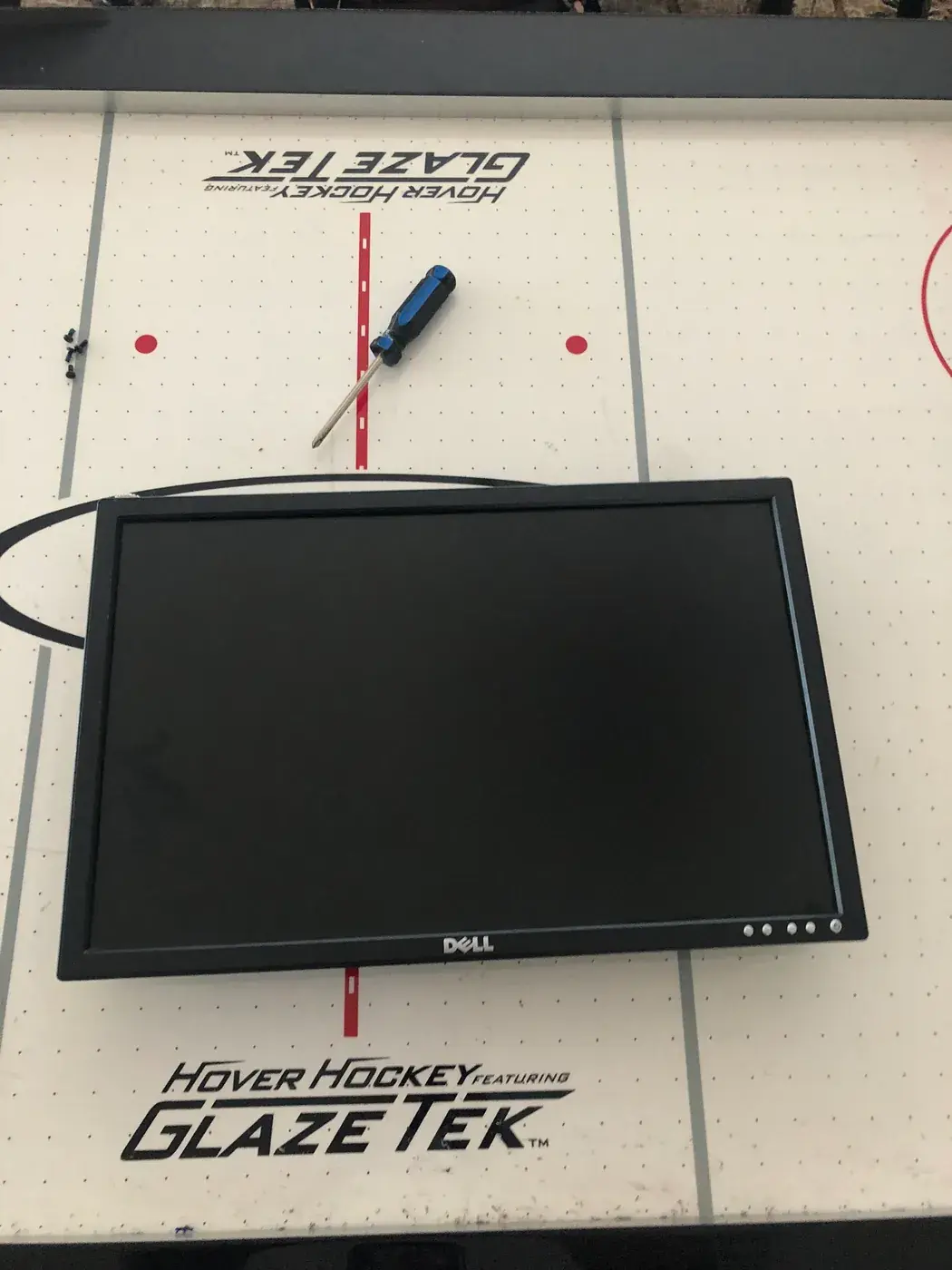 A Dell monitor lying face up on a table.