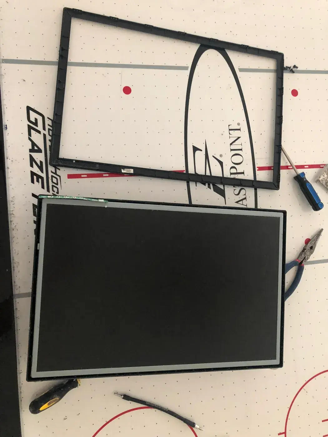 The monitor's panel out of its case, the bezel beside it.