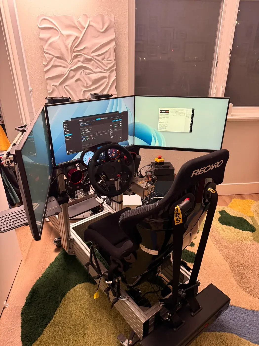 The rig in front of three 27-inch OLEDs wrapping around the seat.