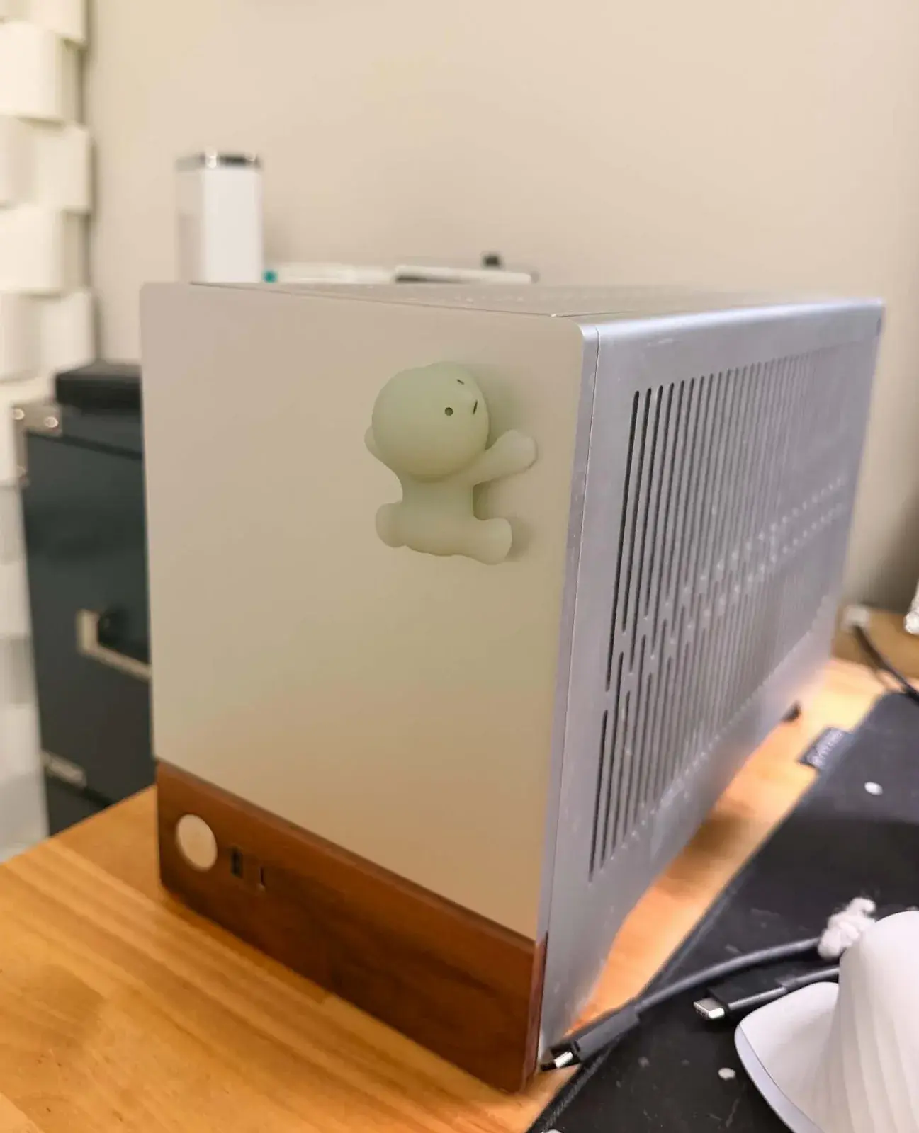 My Fractal Terra on my desk, silver with its walnut foot, a little pale green Smiski climbing its front.